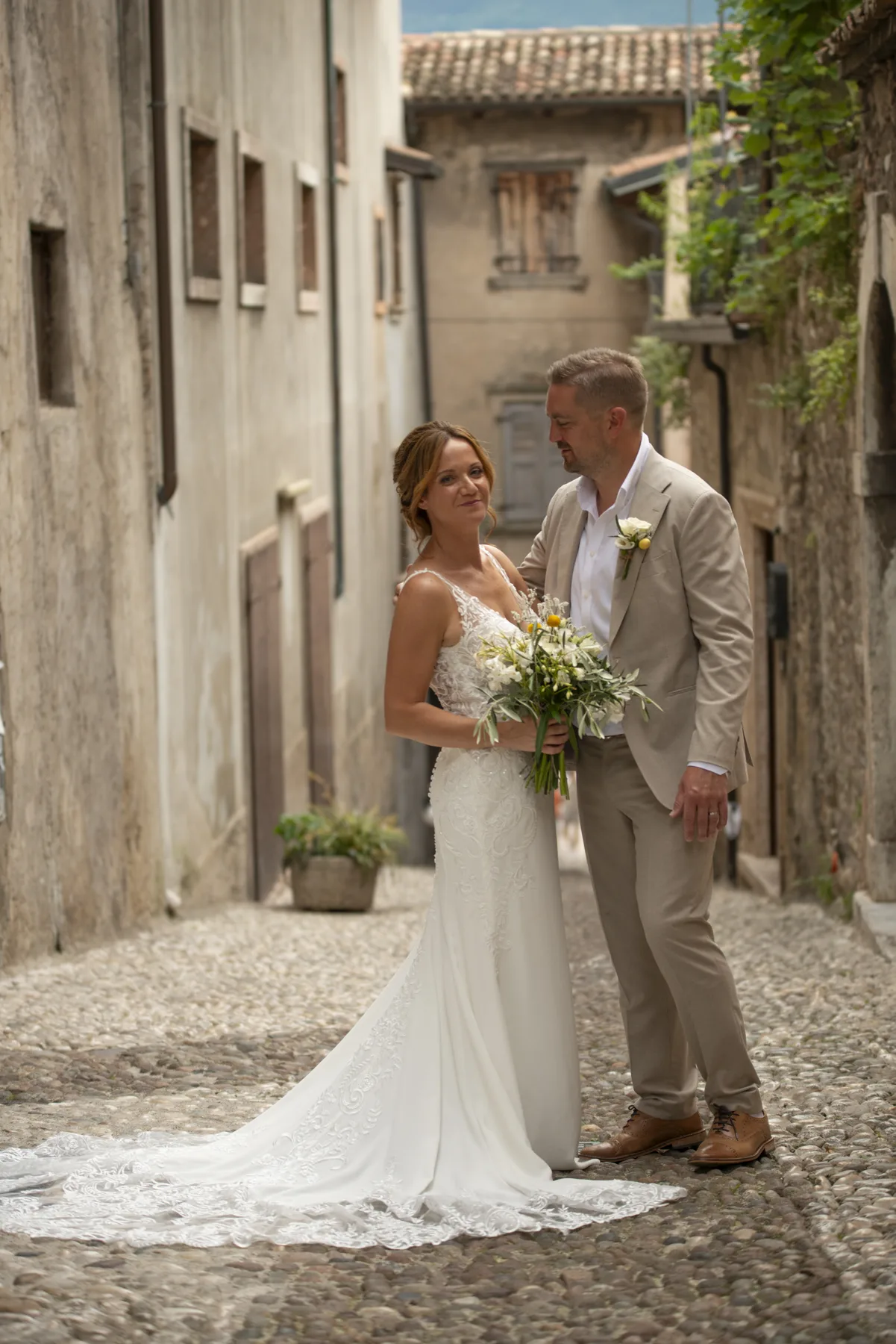 A relaxed portrait of a couple in a cobbled village lane