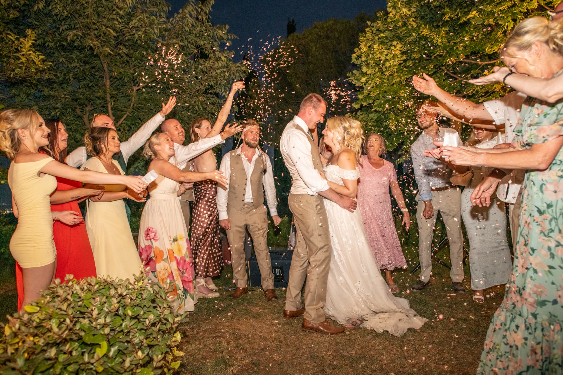 Claudia and Chris surrounded by guests as bubbles fill the air