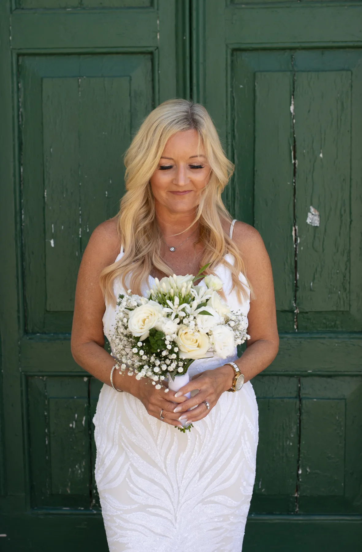 A bride photographed against a green Italian doorway