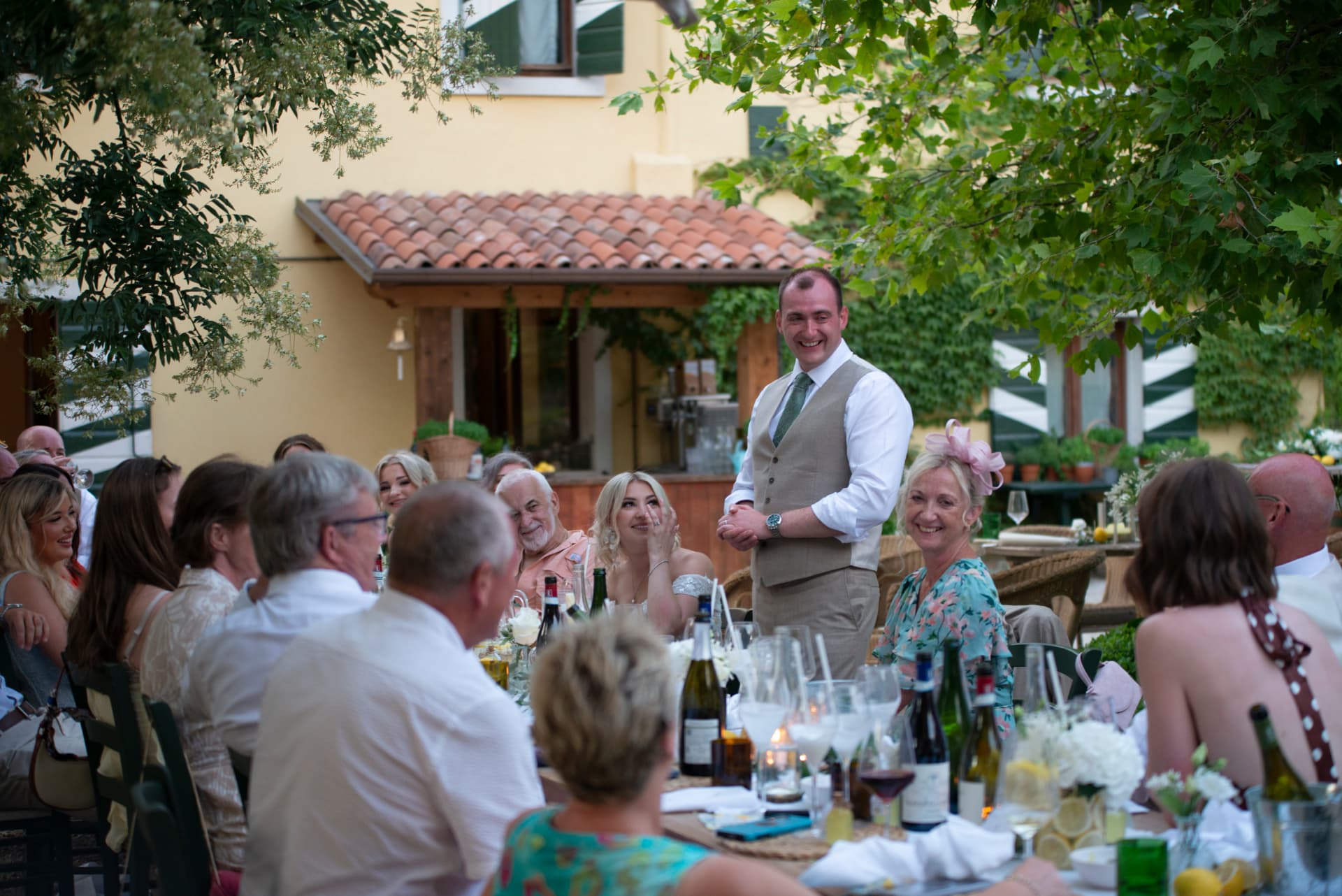 Speeches at the long wedding table in the courtyard at Corte San Mattia