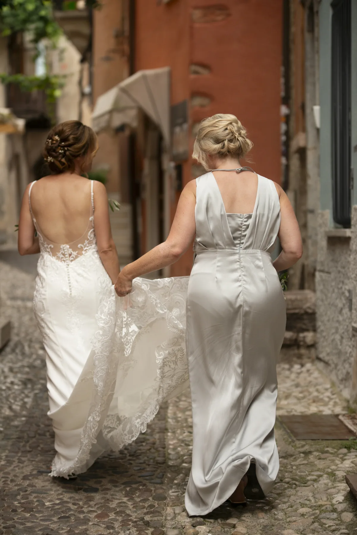 A bride and her bridesmaid walking through an Italian village