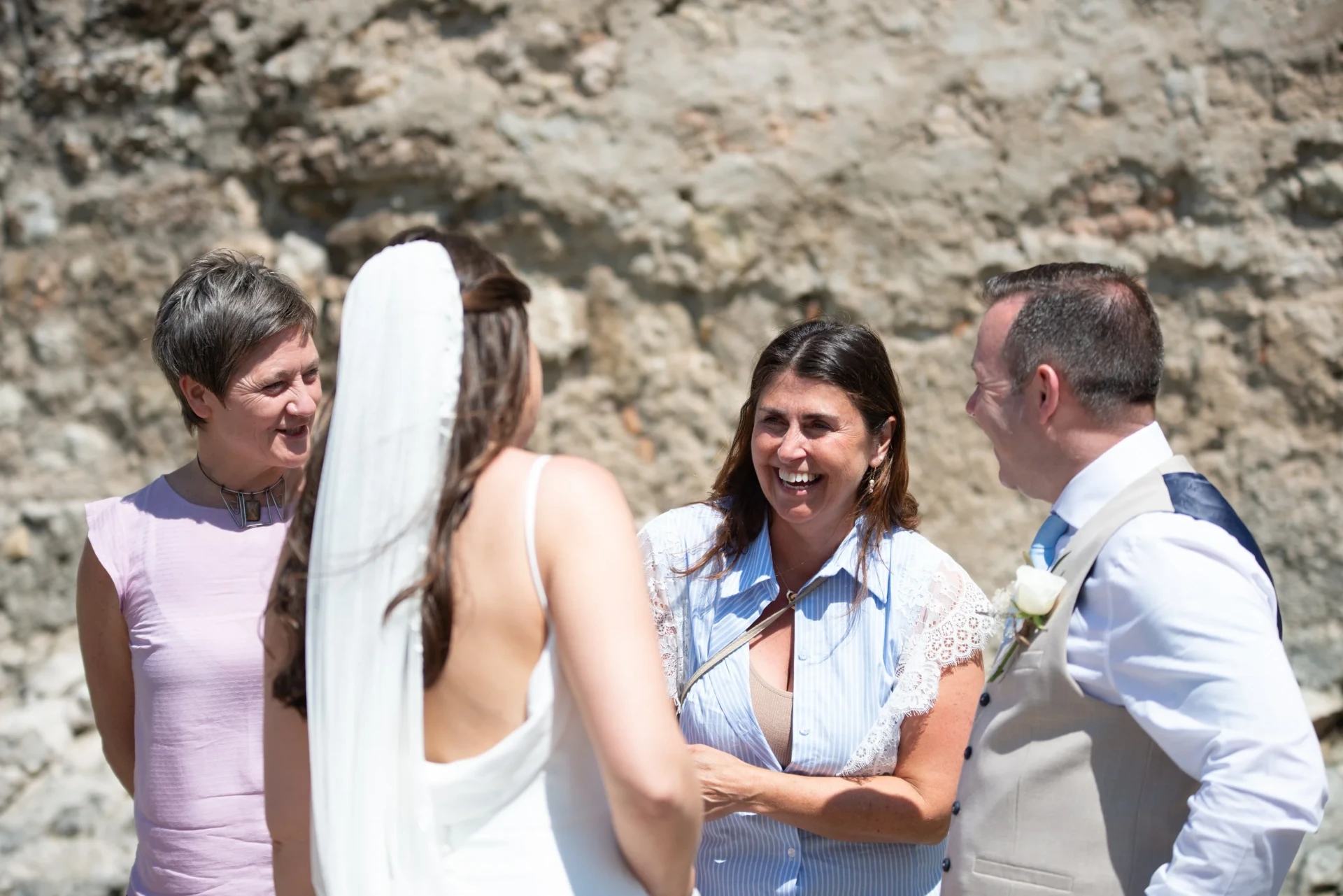 Dulcie laughing with a bride and groom on their wedding day