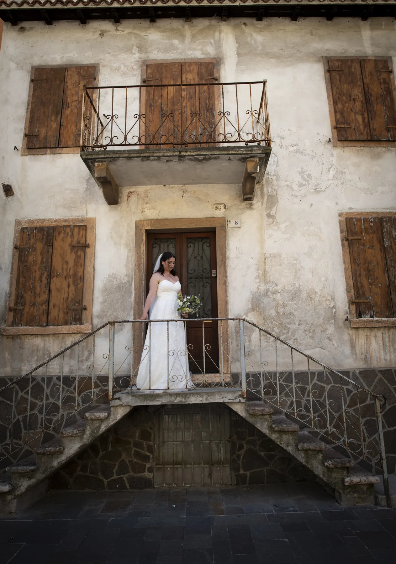 A bride on the steps of a rustic Italian villa