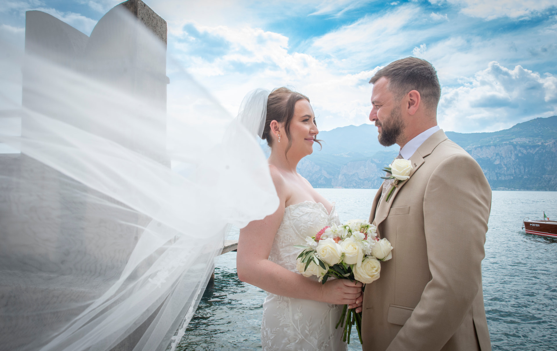 Bride and groom embracing above Lake Garda with sweeping mountain and lake views