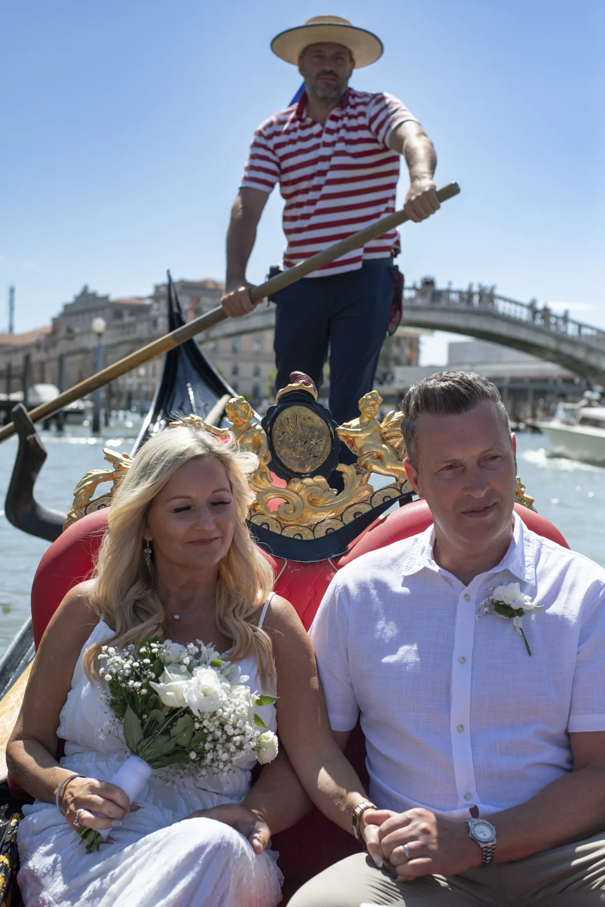 A newlywed couple riding a Venetian gondola
