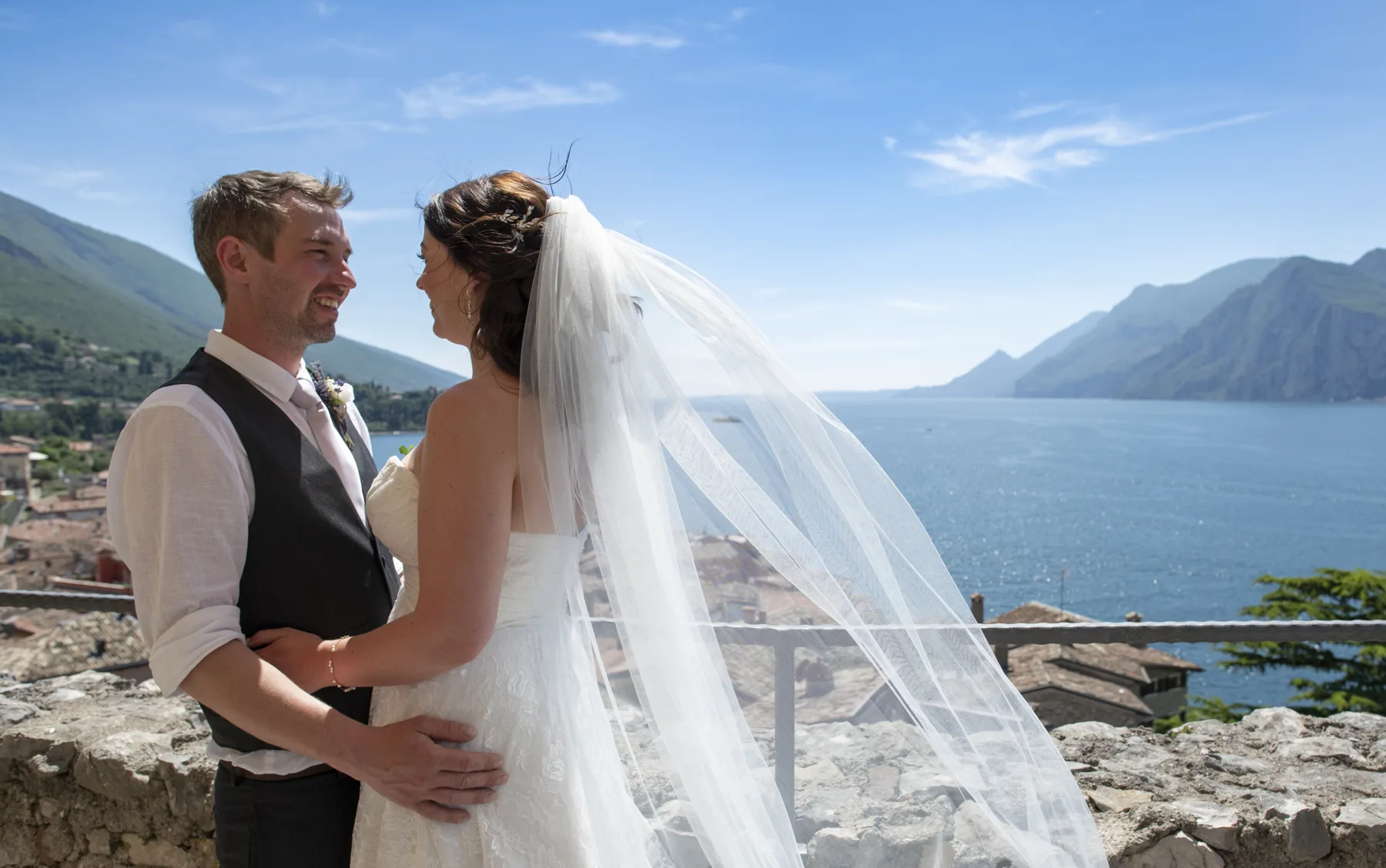 A couple laughing together on the castle walls above the lake