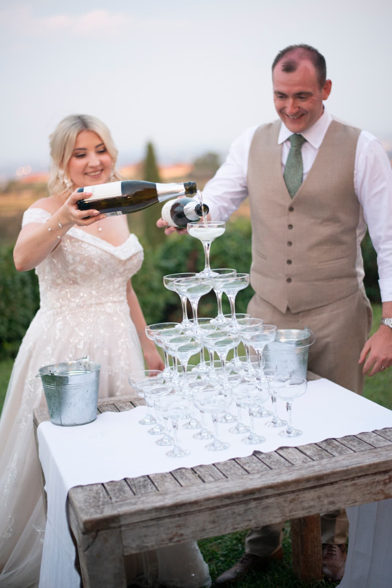 Claudia and Chris pouring the first bottle over the prosecco tower