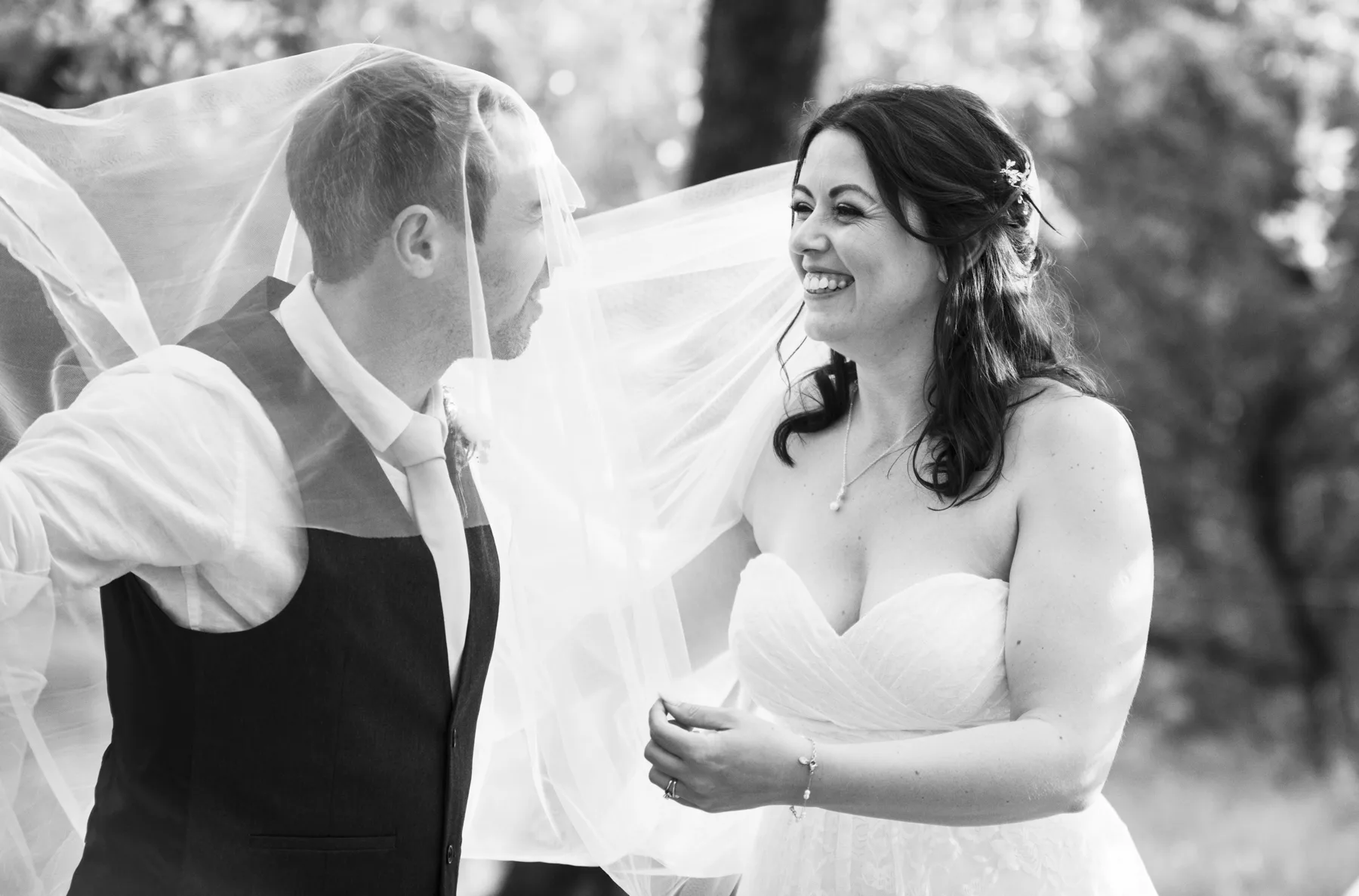 A black and white moment beneath the bride's veil