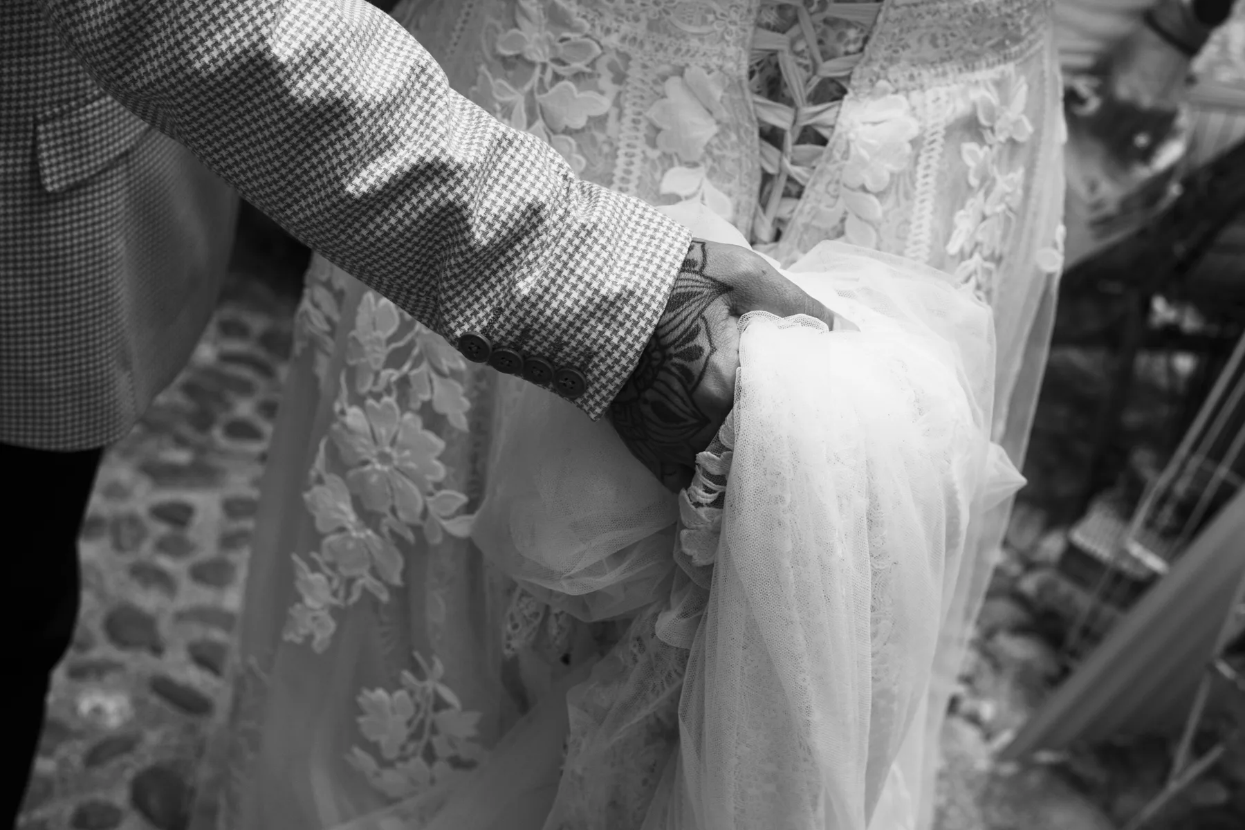 A black and white close up of the couple's hands and rings